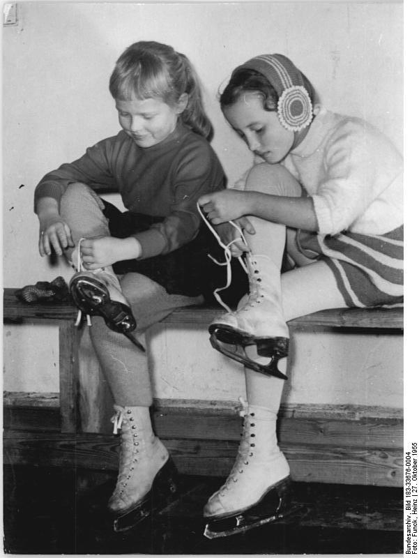 Berlin, Eiskunstlauftraining, Kinder beim Schuhbinden